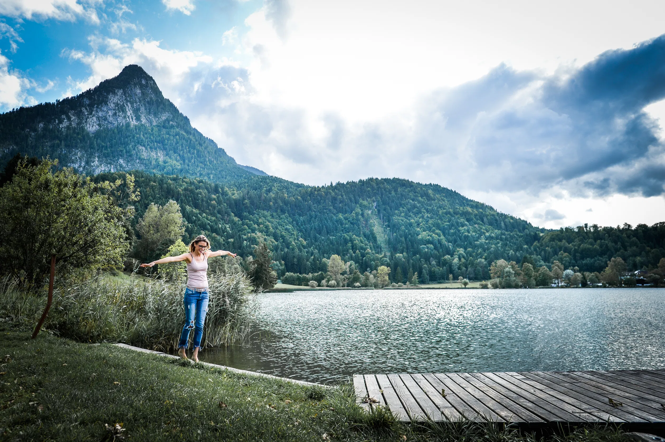 Frau genießt ihr Leben am See mit Bergaussicht