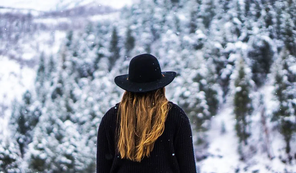 Frau steht mit dem Rücken im Winter